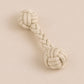 Textured dog toy with braided design on a beige background