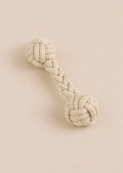 Textured dog toy with braided design on a beige background