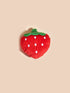 Red strawberry-shaped object with white polka dots on a beige background