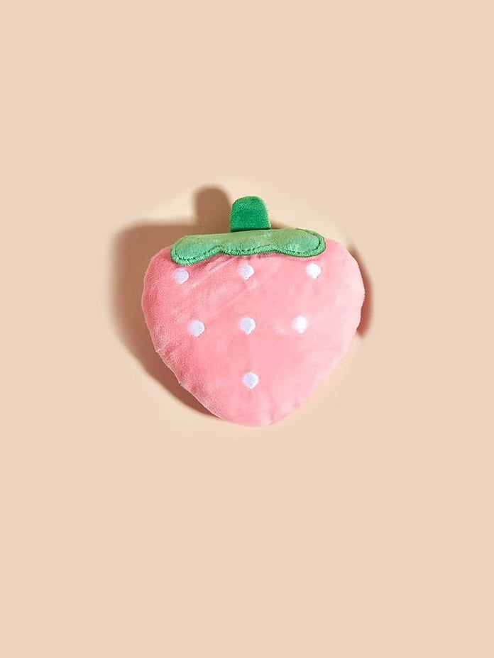 Plush strawberry toy on a beige background